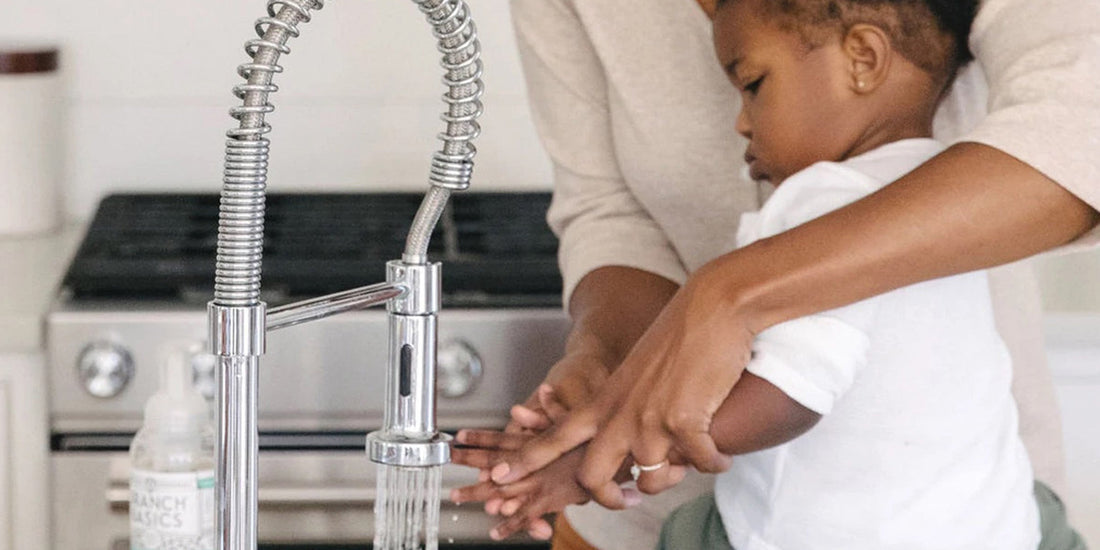 Mother and son washing their hands in the kitchen sink