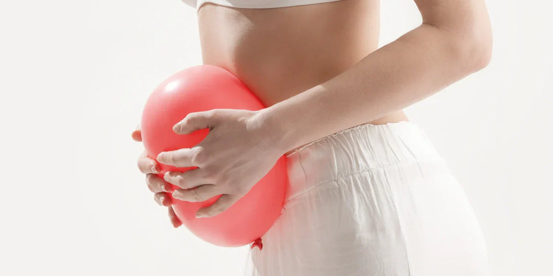 Woman holding a balloon to depict bloating