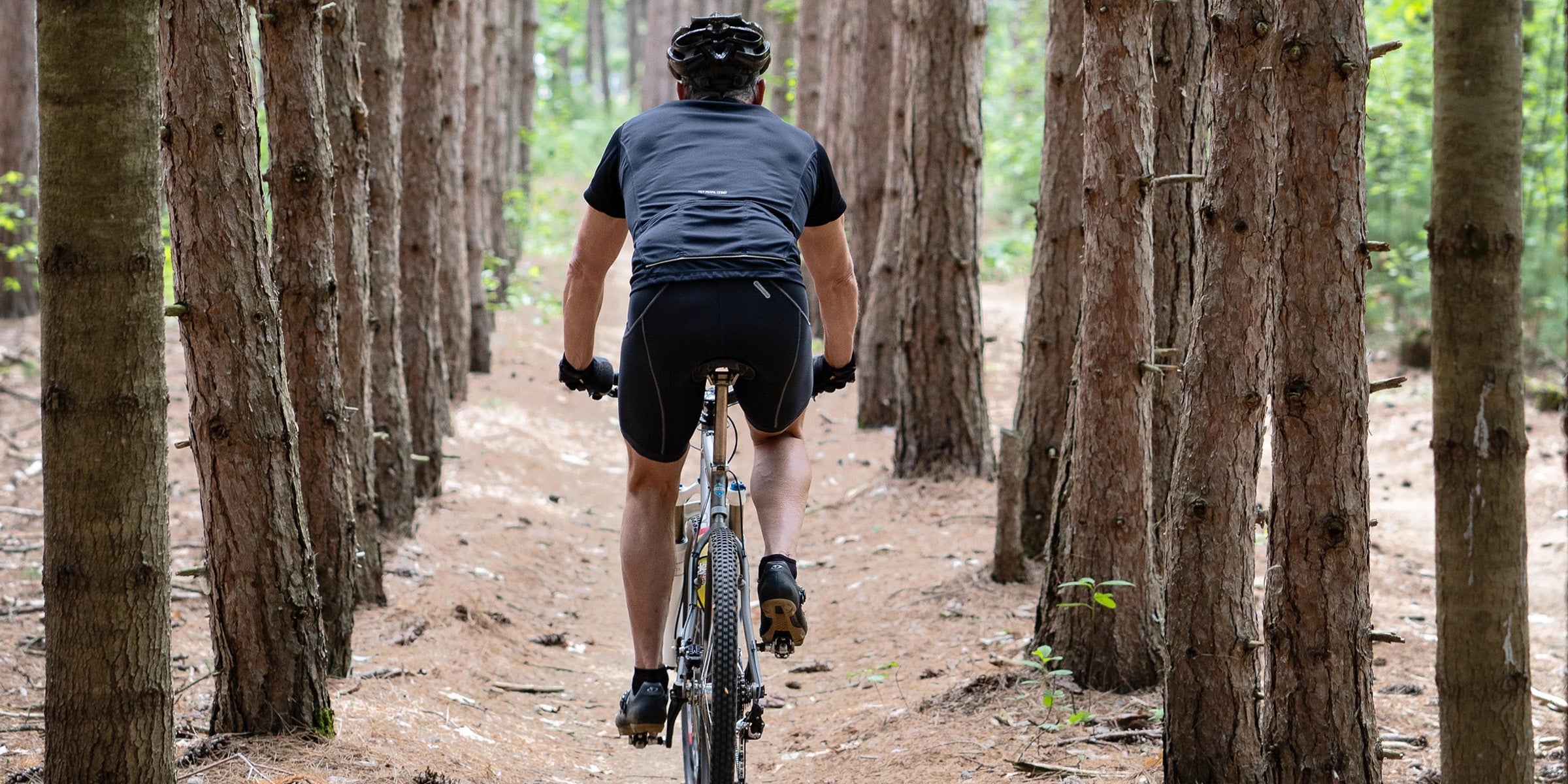 Man riding bike through forest for heart and gut health