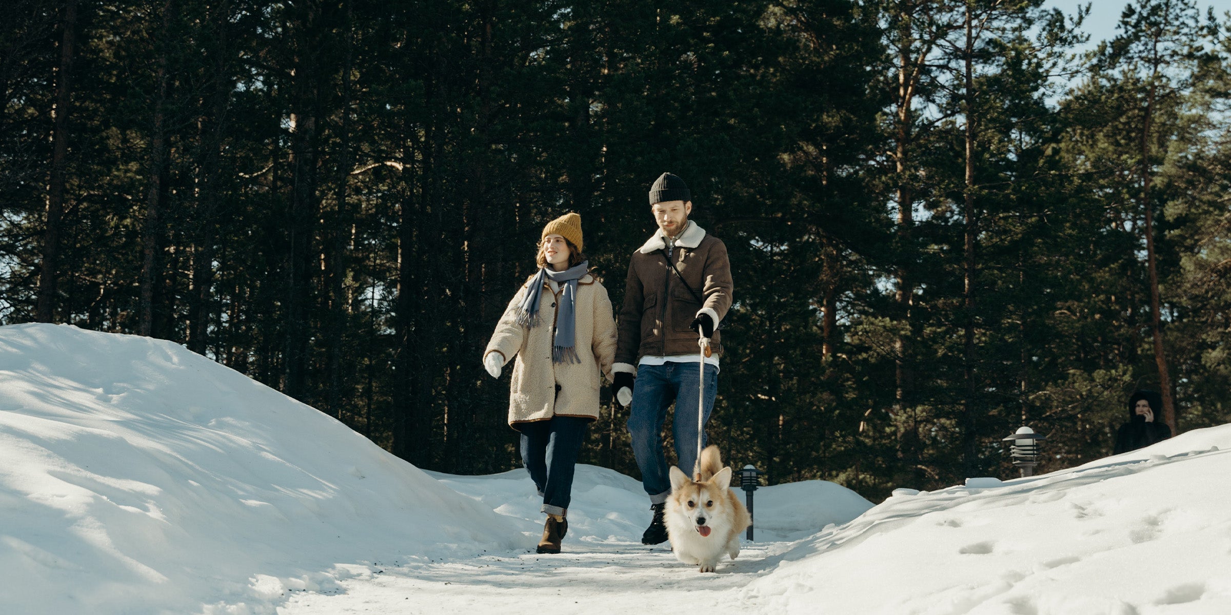 Couple walking their dog in the snow during winter