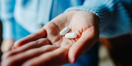 Person holding antibiotic pills in their hand