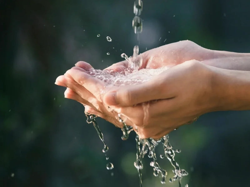 Hands catching falling water