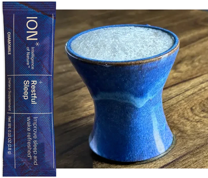 Mug with chamomile latte and a packet of ION Restful Sleep