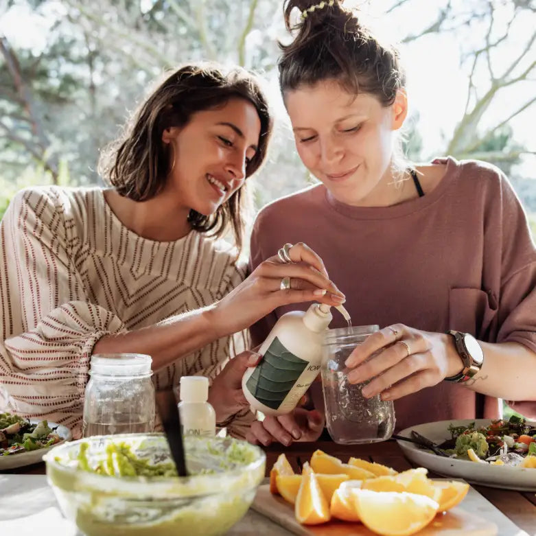 Women pouring ION Gut Support in glass